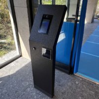 マンション入口のオートロック操作板。 黒い大理石調の自立型のパネルで、操作パネル面が少し斜めに傾いている。